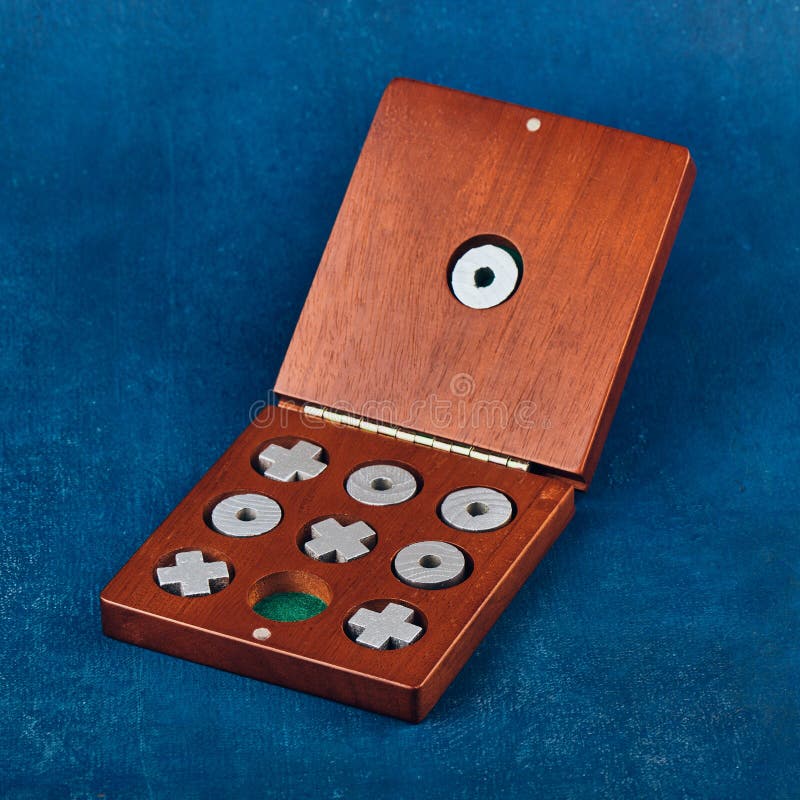 Tabletop Game of Tic Tac Toe in a Wooden Box on a Blue Background