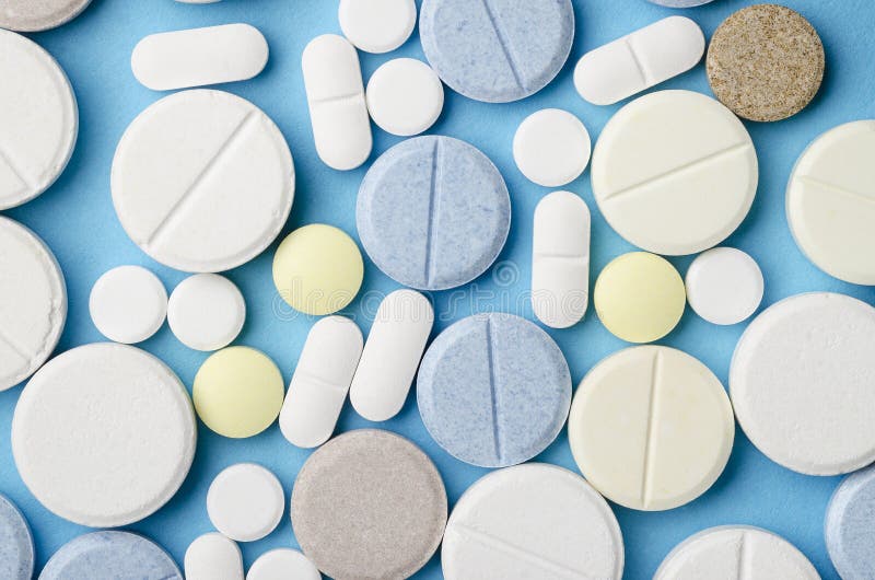 Tablets of Different Shapes and Colors Closeup on Pink Background