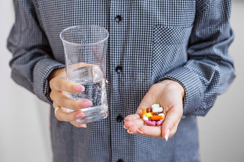 Tablets and a glass of water in their hands. Concept illness, co royalty free stock photo Tablets and a glass of water in their hands. Concept illness, co royalty free stock photo