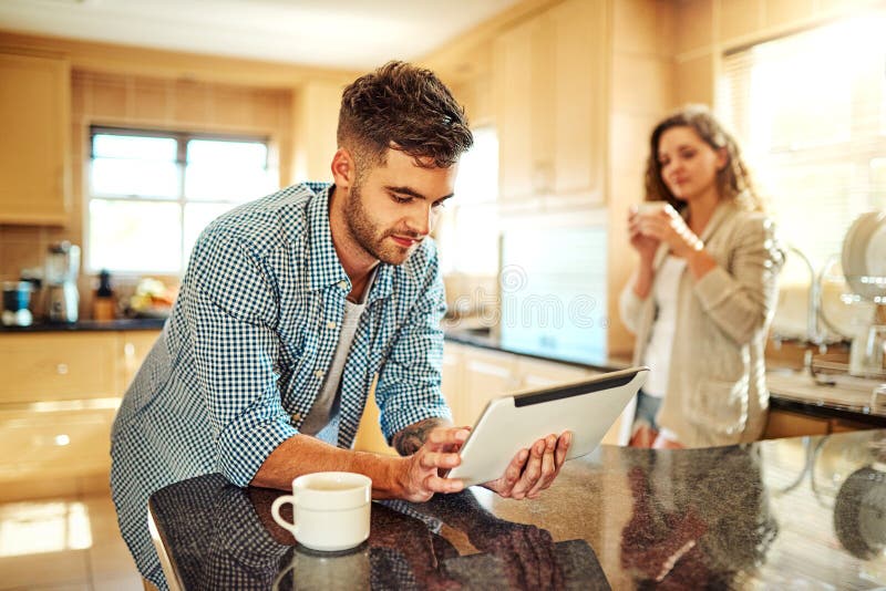 Tablette und Küche mit Kaffee zum Surfen am Morgen oder Software App zu Hause. junger Mann mit lizenzfreies stockbild