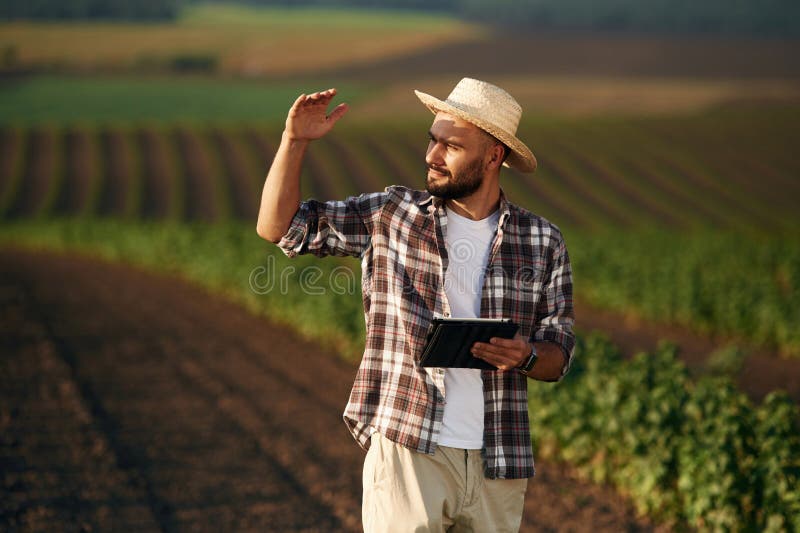 Tabletă digitală în mâini. Fermierul este pe terenul agricol royalty free stock photos