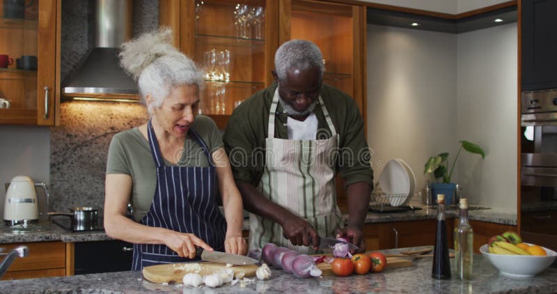 Tabliers De Port De Couples Supérieurs En Difficulté Métisse Réduisant Les  Légumes Ensemble Dans La Cuisine à La Maison Clips Vidéos - Vidéo du tablier,  adulte: 207596137