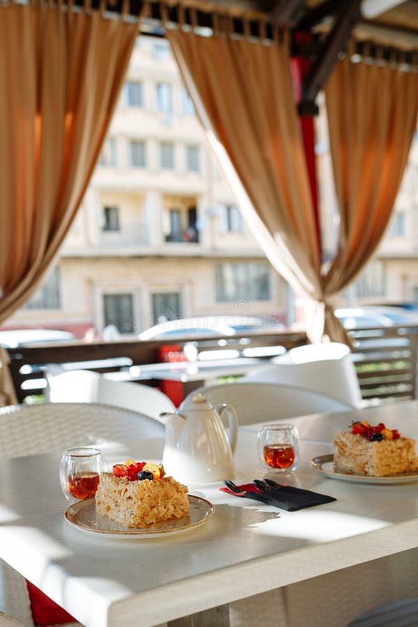 Taca z teapot, filiżankami i tortami na stole w kawiarni przeciw okno, fotografia royalty free Taca z teapot, filiżankami i tortami na stole w kawiarni przeciw okno, fotografia royalty free