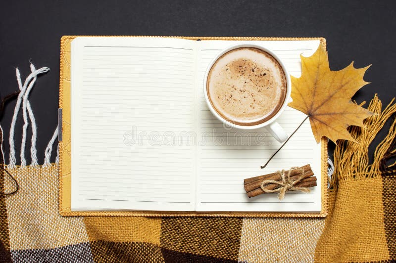Taccuino aperto, tazza del cacao della zucca o caffè, cannella, foglia di acero gialla di autunno, plaid a quadretti marrone aran immagine stock