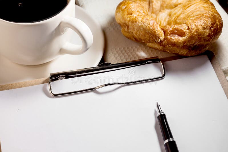 Taccuino, penna, tazza di caffè e croissant fotografie stock libere da diritti Taccuino, penna, tazza di caffè e croissant fotografie stock libere da diritti