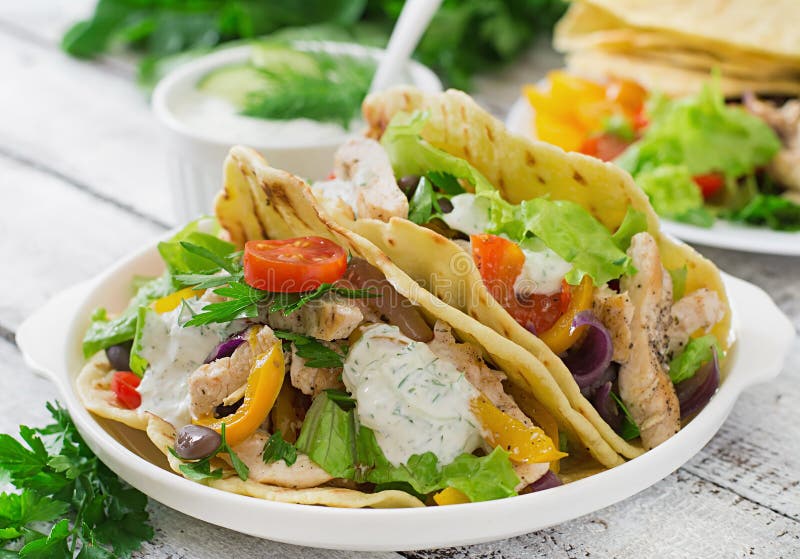 Tacos mexicain avec le poulet, les haricots noirs et les légumes frais et la sauce à tartre photo libre de droits Tacos mexicain avec le poulet, les haricots noirs et les légumes frais et la sauce à tartre photo libre de droits
