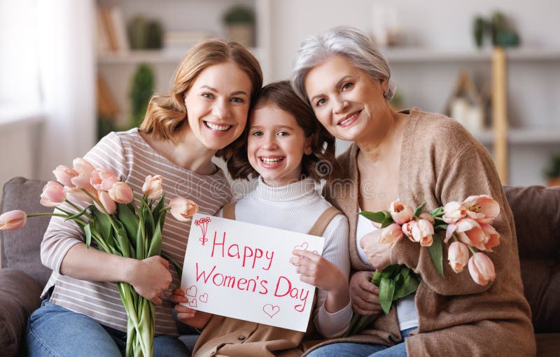 Tag der glücklichen internationalen Frauen. Großmutter und Tochter mit Blumen und einem Plakat feiern ihren Urlaub stockbild