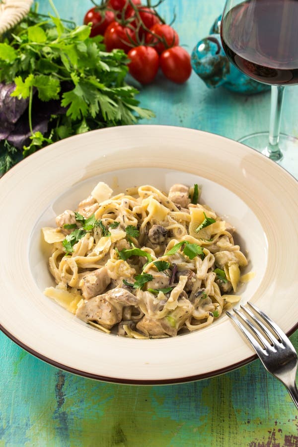 Tagliatelle Pasta with Mushrooms and Chicken on Blue Wooden Table Stock
