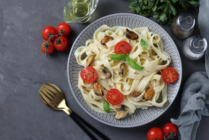 Tagliatelle Pasta with Mussels and Cherry Tomatoes on a Gray Plate