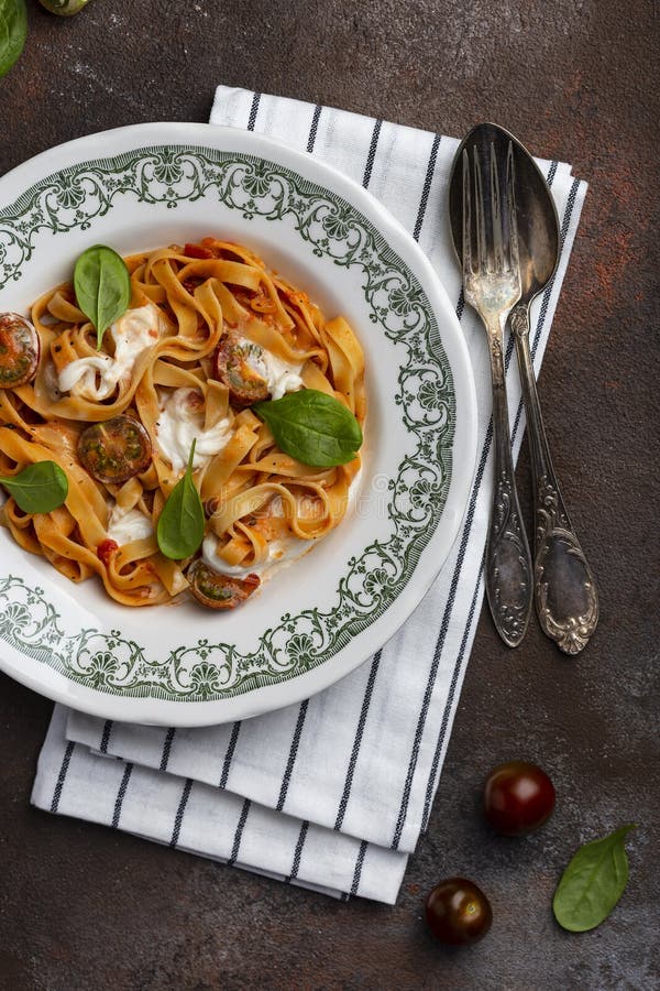 Tagliatelle Pasta with Tomatoes and Stracciatella Cheese Stock Photo