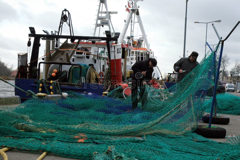 Taglierine e pescatori dopo la pesca durante il giorno molto scuro e tempestoso immagini stock Taglierine e pescatori dopo la pesca durante il giorno molto scuro e tempestoso immagini stock