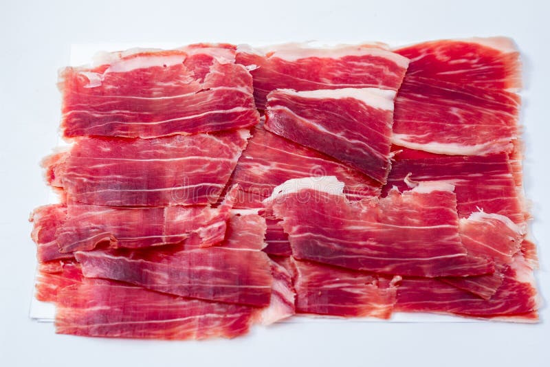 Taglio iberico del prosciutto sul vassoio bianco fotografia stock libera da diritti Taglio iberico del prosciutto sul vassoio bianco fotografia stock libera da diritti