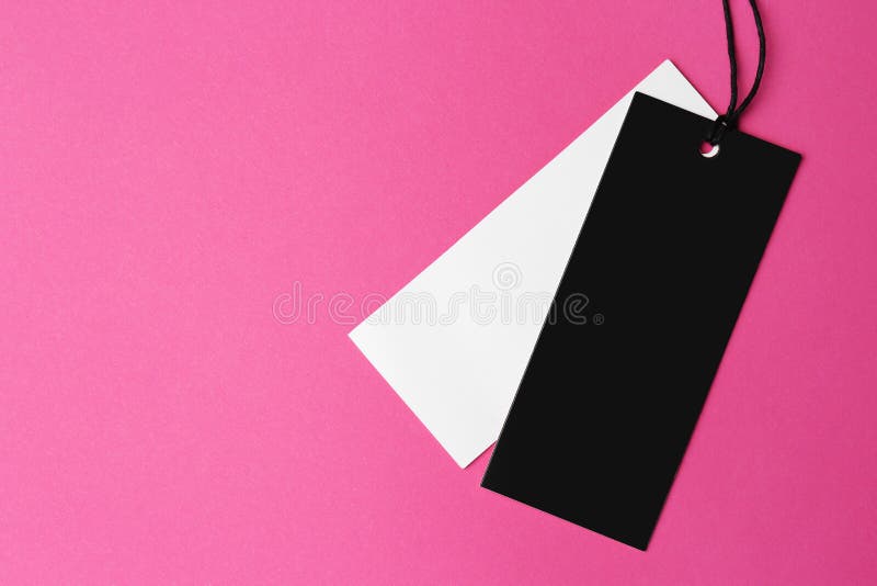 Tags with space for text on pink background, top view