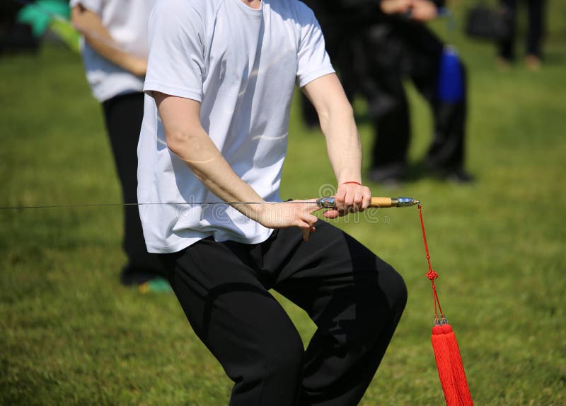 Tai Chi Martial Arts Athlete Makes Motions with Sword Stock Image
