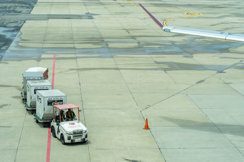Tailandia, Don Muang International Airport, Bangkok, - 23 de julio de 2018: Flete las carretillas con equipaje cargado en la pist fotografía de archivo Tailandia, Don Muang International Airport, Bangkok, - 23 de julio de 2018: Flete las carretillas con equipaje cargado en la pist fotografía de archivo