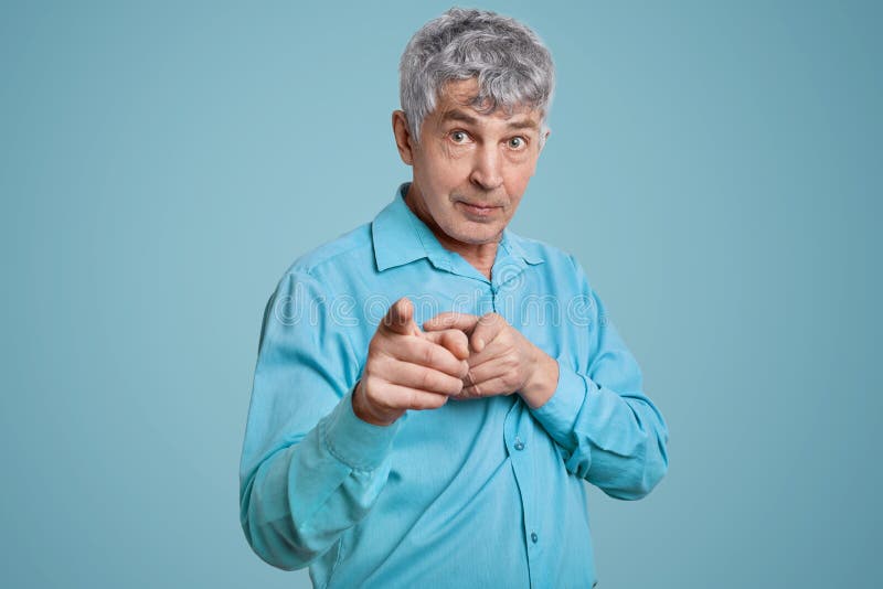 Taille herauf Porträt des überzeugten reifen Mannpensionärs zeigt mit beiden Zeigefingern auf die Kamera, gekleidet im blauen for stockfoto Taille herauf Porträt des überzeugten reifen Mannpensionärs zeigt mit beiden Zeigefingern auf die Kamera, gekleidet im blauen for stockfoto