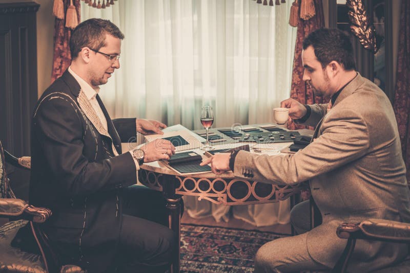 Tailor and client choosing materials for suit stock images Tailor and client choosing materials for suit stock images