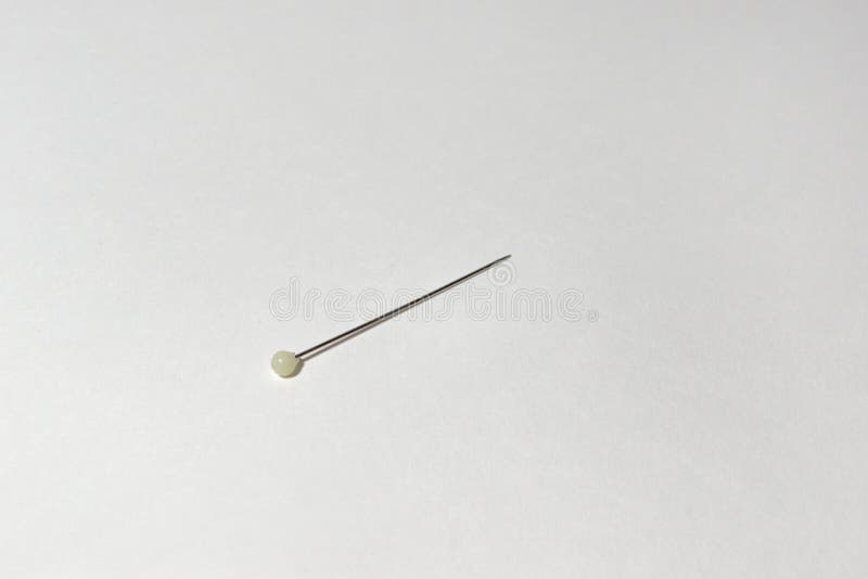 A tailor`s pin with white ball-shape finial