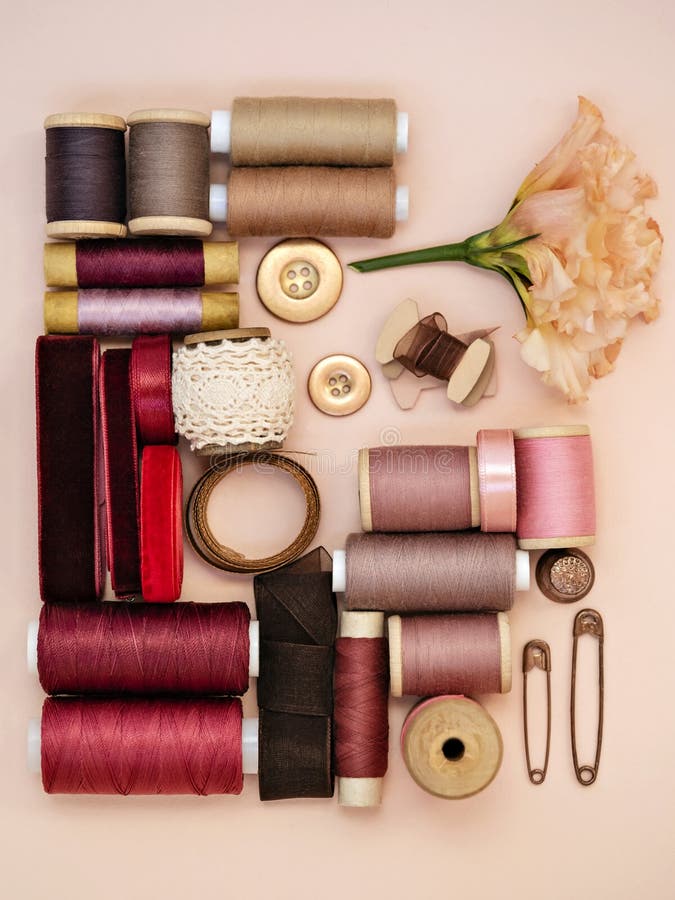 tailoring-accessories-natural-tones-top-view-sewing-supplies-as-various-ribbons-bobbin-pins-pink-background-flat-lay-178954347.jpg