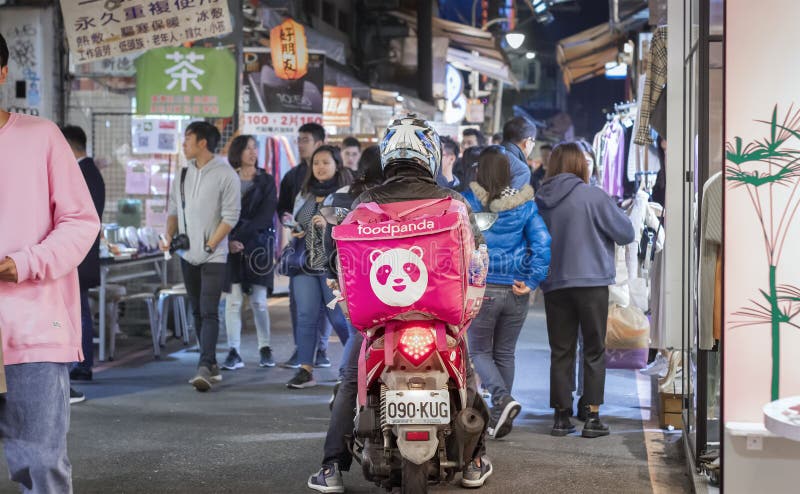 TAIPEI, TAIWAN - JANUARY 09: Foodpanda delivery rides through crowded walking street in Shilin Night Market in Taipei on January 09, 2020.