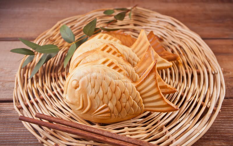 Taiyaki Japanese street food fish-shaped sweet filling waffle on wooden table