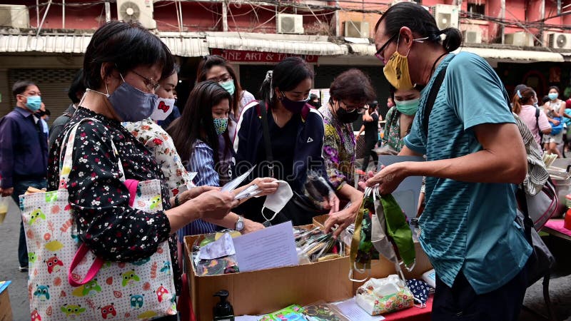 Tajlandia bangkok 22 kwietnia 2020 r. : tłum tajskich ludzi wybierających maskę twarzy u sprzedawcy ulicy podczas epidemii wirusa