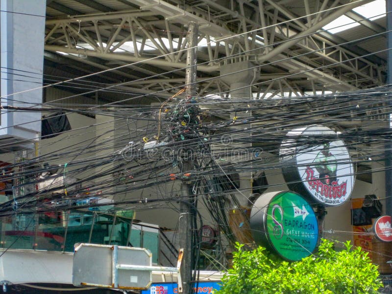 TAJLANDIA PHUKET, MARZEC, - 26, 2012: Chaos kable i druty na elektrycznym słupie Druciany i kablowy zagracenie obraz stock TAJLANDIA PHUKET, MARZEC, - 26, 2012: Chaos kable i druty na elektrycznym słupie Druciany i kablowy zagracenie obraz stock