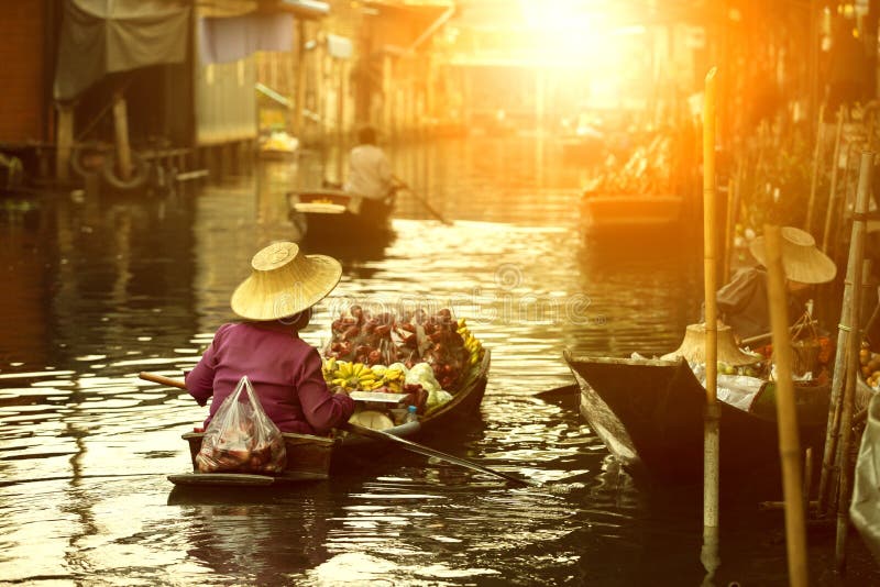Tajlandzki owocowy sprzedawca żegluje drewnianą łódź w Thailand tradycji spławowym rynku