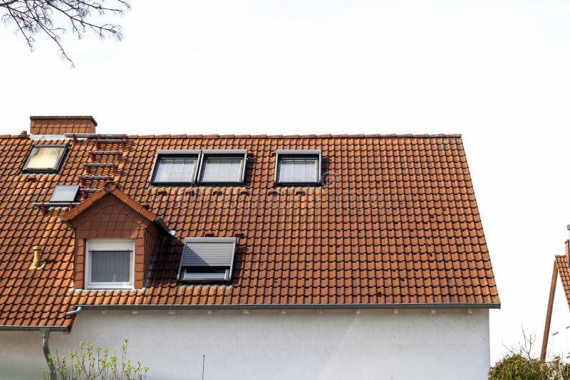 Tak av klassiska bostads- hus med orange tegelpannor och royaltyfri bild Tak av klassiska bostads- hus med orange tegelpannor och royaltyfri bild