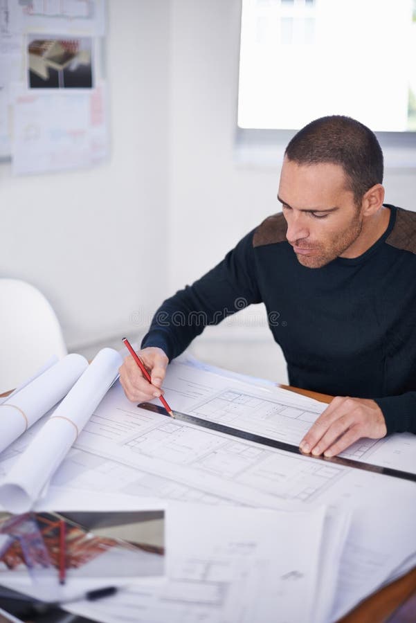 He takes great pride in the accuracy of his work. an architect drafting up building plans. royalty free stock images