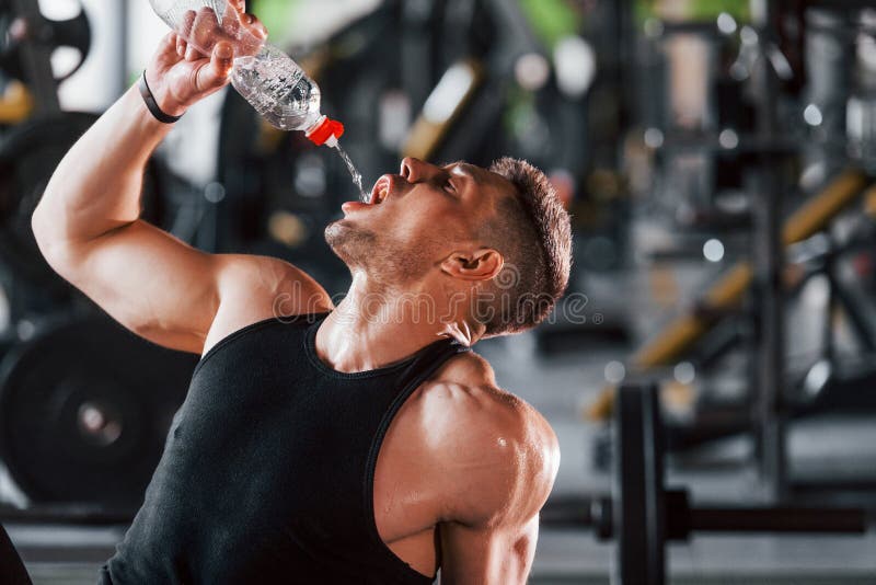 Water Bottle Black Man In Gym And Smartphone For Social Media After Fitness  Exercise Healthy Sports Workout And Muscle Growth Wellness Work Out  Training Motivation And A Tired Guy Drinking Water Stock