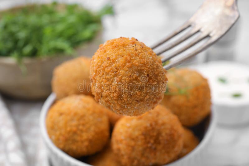 Taking Delicious Fried Tofu Ball with Fork from Bowl, Closeup Stock