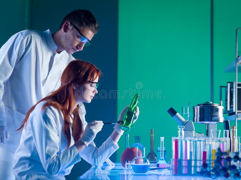 Side view of two forensics scientists taking fingerprints from bottle, in a laboratory