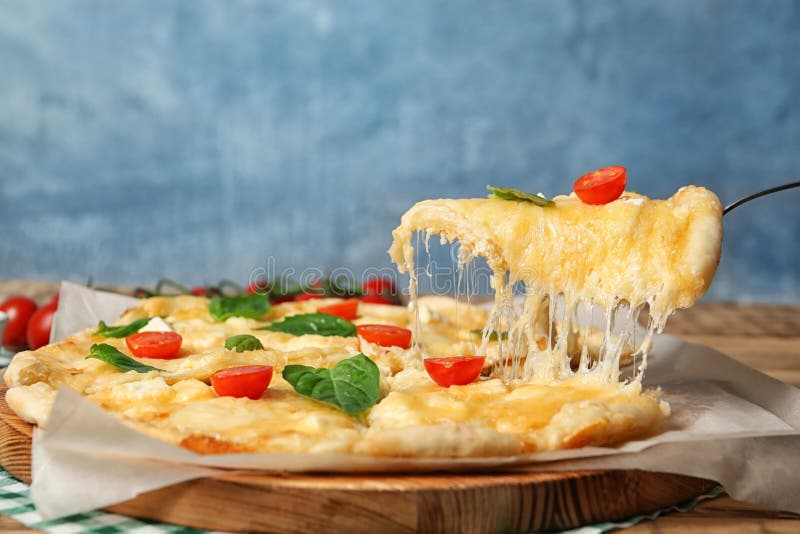 Taking tasty homemade pizza slice with melted cheese stock photo Taking tasty homemade pizza slice with melted cheese stock photo