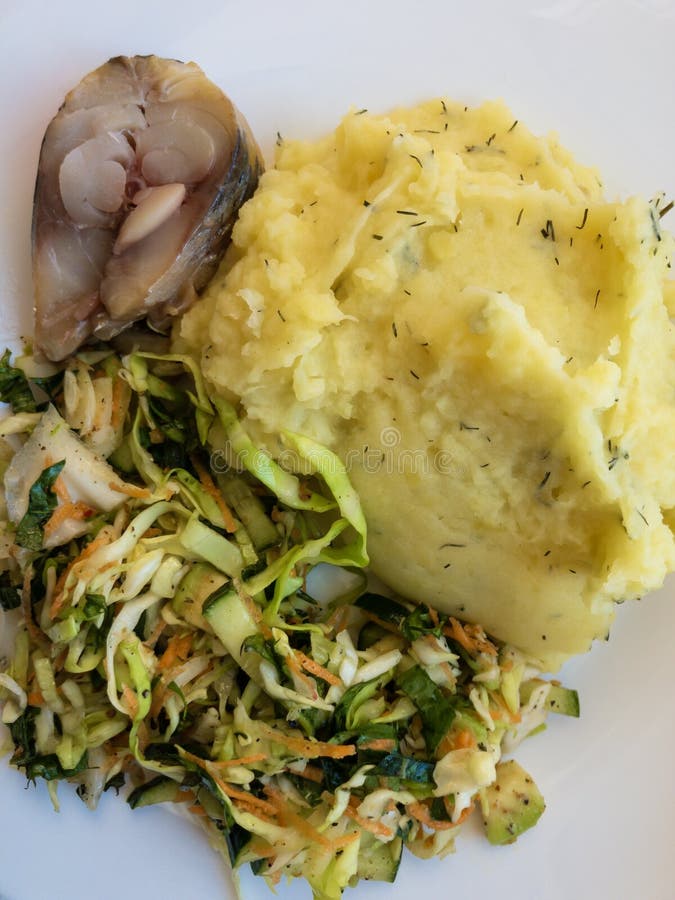 Talerz z kawałkiem śledź, kartoflana breja, kapuściana sałatka mieszająca z marchewkami i dandelion liście, obrazy stock Talerz z kawałkiem śledź, kartoflana breja, kapuściana sałatka mieszająca z marchewkami i dandelion liście, obrazy stock