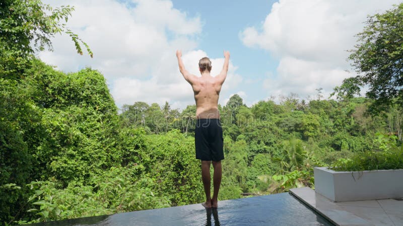 A Tall Athletic Young Man in Black Shorts Stands on the Edge of the View  Pool and Does Morning Exercises. a Young Man Stock Video - Video of  activity, care: 232049607