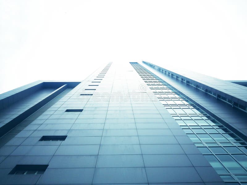 The tall building from the bottom view has a white sky background royalty free stock photography The tall building from the bottom view has a white sky background royalty free stock photography