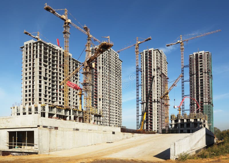 Tall buildings under construction with cranes