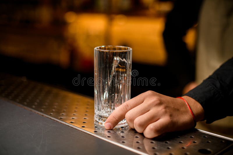 Two tall cocktail glasses half full of ice and metal jiggers on the bar  counter Stock Photo by ©Fesenko 336646890