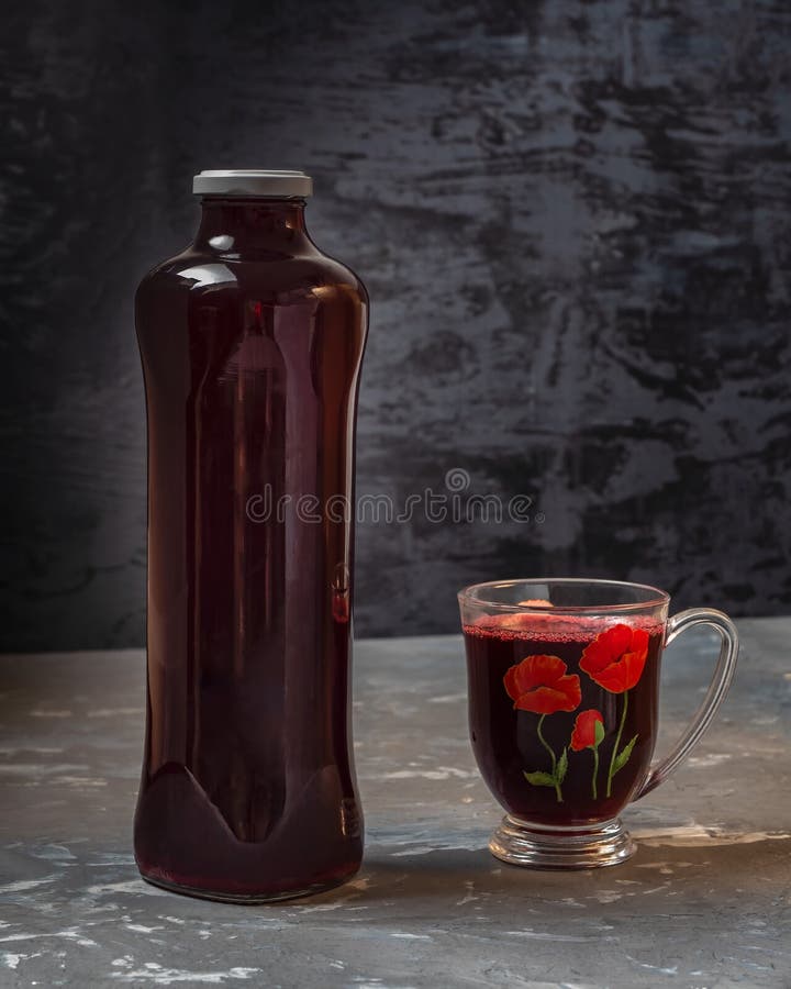 Tall Glass Bottle with Berry Fruit Drink and Mug Filled with Drink