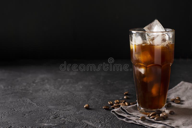 Tall glass cold brew coffee with ice on black stock photos