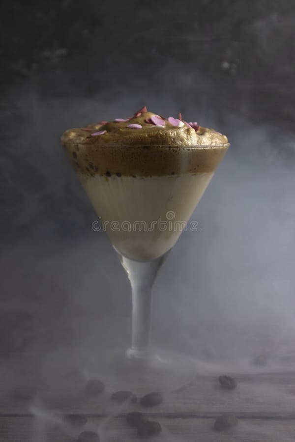 In a tall martini glass cold Dalgona Coffee, trendy Korean drink royalty free stock photography