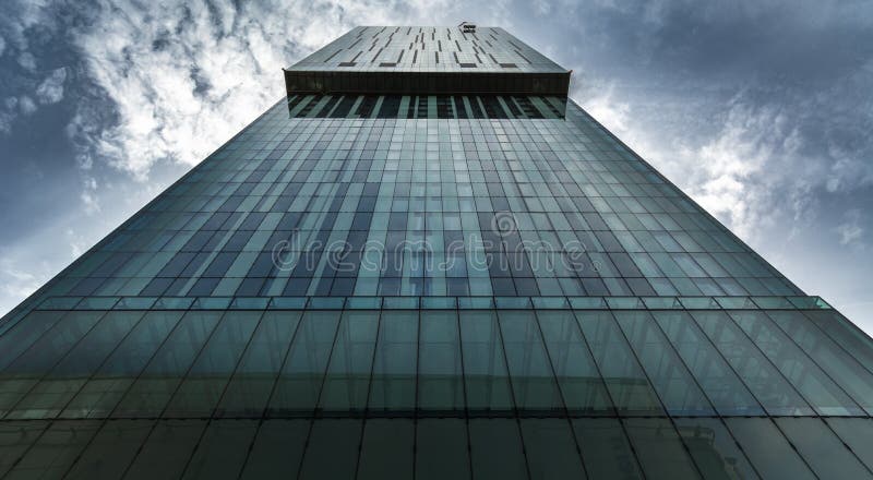 Tall Urban Skyscraper In Financial District With Moody Dramatic Clouds.