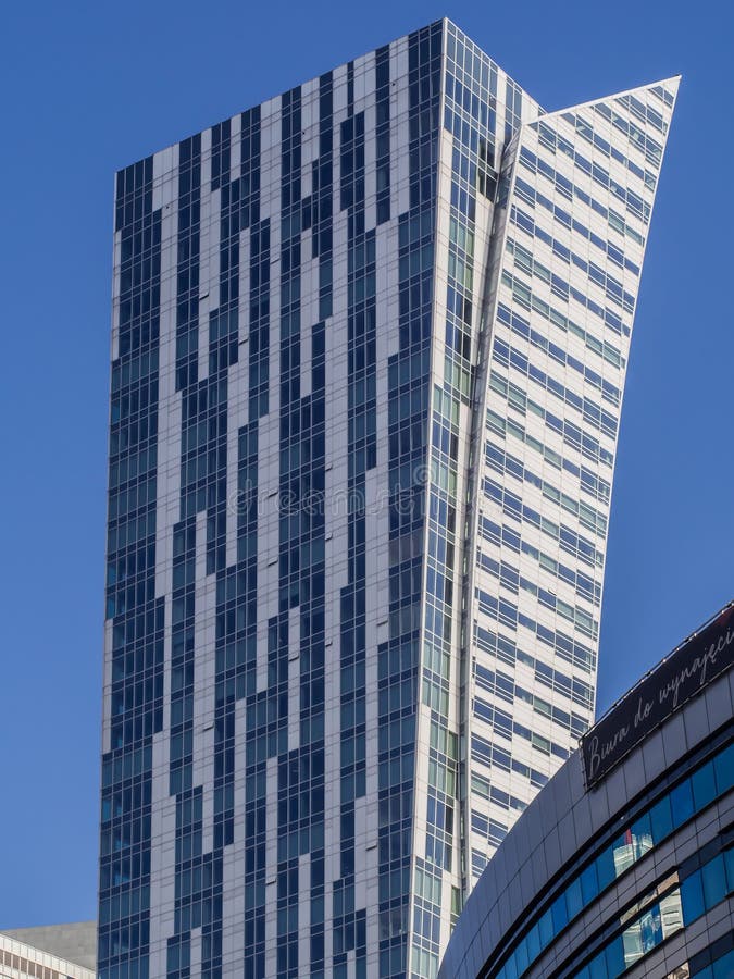 A tall white-blue building against a blue sky stock images