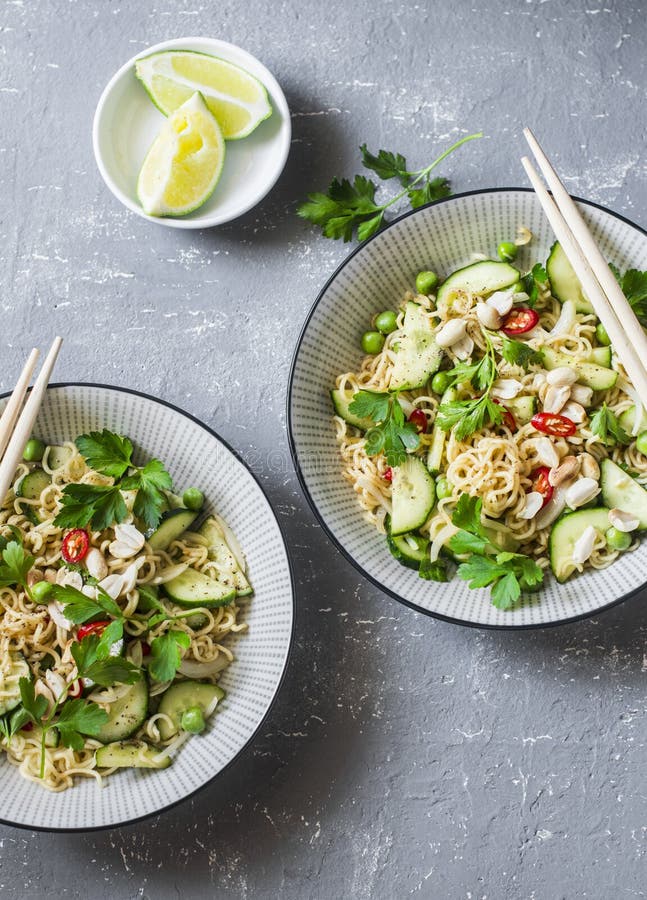 Tallarines de Ramen y ensalada caliente conservada en vinagre en un fondo gris, visión superior del pepino foto de archivo