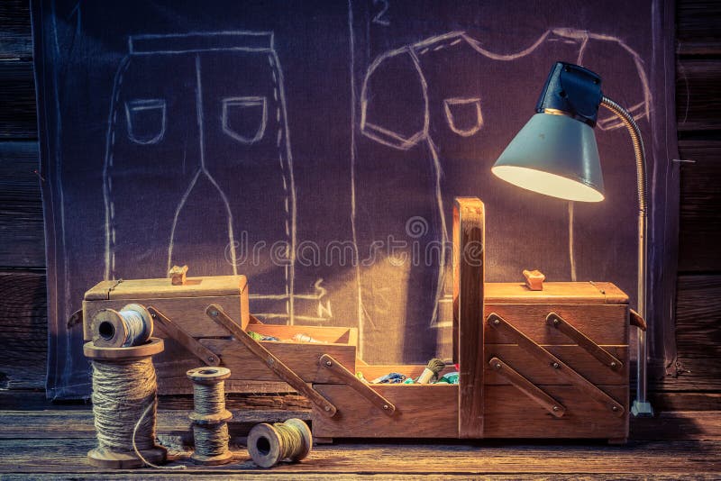 Taller viejo del sastre con las agujas, los hilos y los materiales stock de ilustración Taller viejo del sastre con las agujas, los hilos y los materiales stock de ilustración
