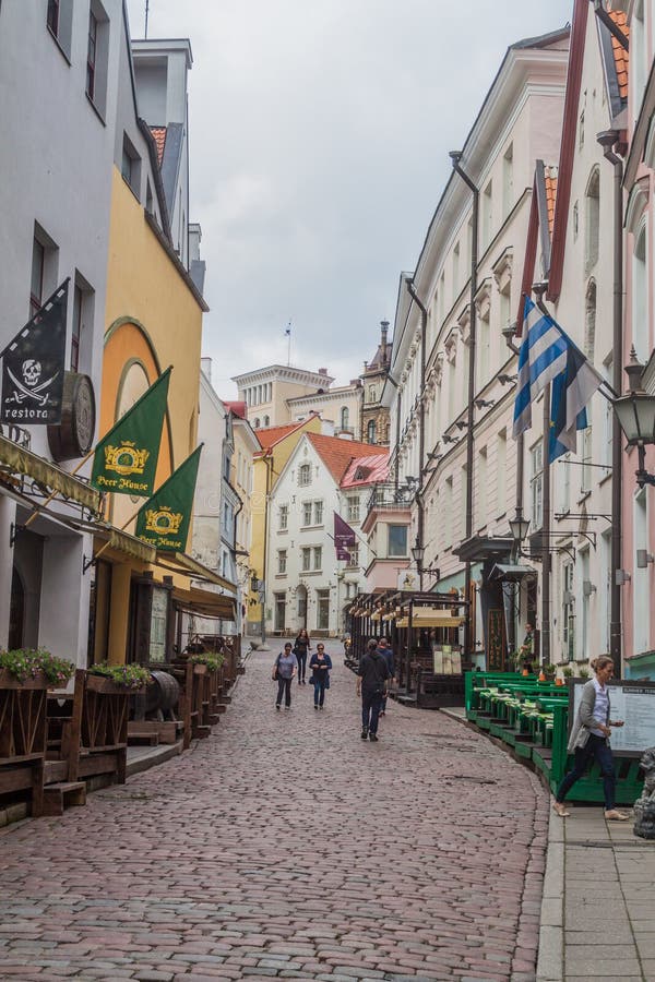 TALLINN, ESTONIE - 23 AOÛT 2016 : Les gens marchent sur une rue pavée en cailloutis étroite dans la vieille ville dans Tallin images stock TALLINN, ESTONIE - 23 AOÛT 2016 : Les gens marchent sur une rue pavée en cailloutis étroite dans la vieille ville dans Tallin images stock