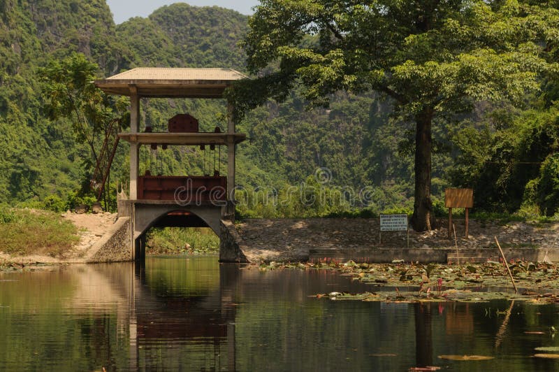 Tam coc, Vietnam; 08 10 2019: Sampan boat-ride, rowed by a villager at Tam Coc , Vietnam : the karst landscape with many vertical sides and covered by much green vegetation. Tam coc, Vietnam; 08 10 2019: Sampan boat-ride, rowed by a villager at Tam Coc , Vietnam : the karst landscape with many vertical sides and covered by much green vegetation.