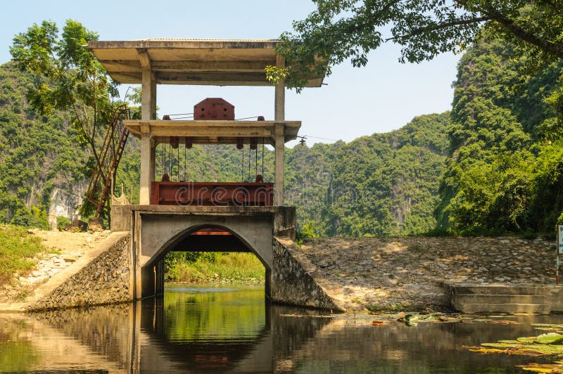 Tam coc, Vietnam; 08 10 2019: Sampan boat-ride, rowed by a villager at Tam Coc , Vietnam : the karst landscape with many vertical sides and covered by much green vegetation. Tam coc, Vietnam; 08 10 2019: Sampan boat-ride, rowed by a villager at Tam Coc , Vietnam : the karst landscape with many vertical sides and covered by much green vegetation.