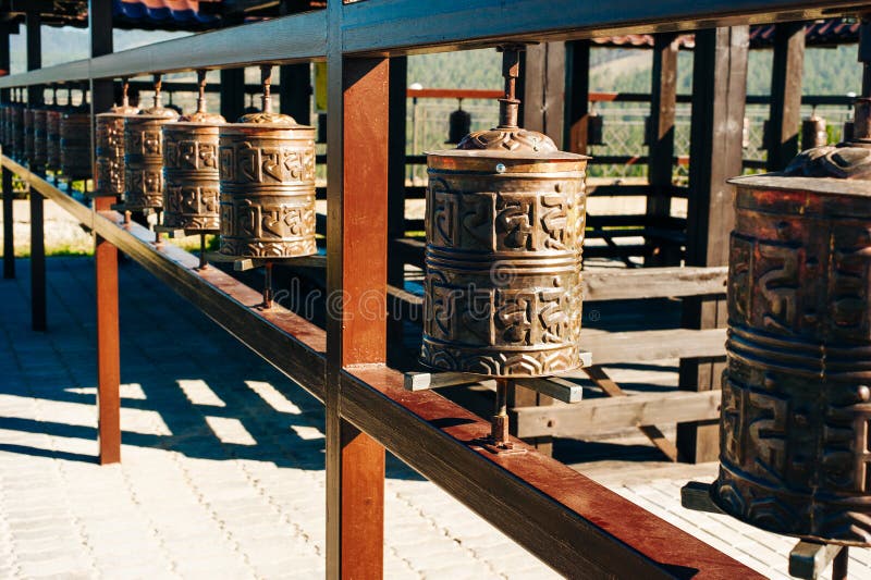Tamburo di preghiera Vecchi cilindri di preghiera in Nepal Ruote di preghiera tibetane buddisti in fila fotografia stock Tamburo di preghiera Vecchi cilindri di preghiera in Nepal Ruote di preghiera tibetane buddisti in fila fotografia stock